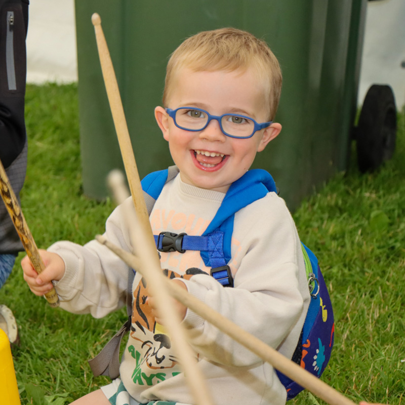 Child having fun with Mr Samba drumming at the family fun day.